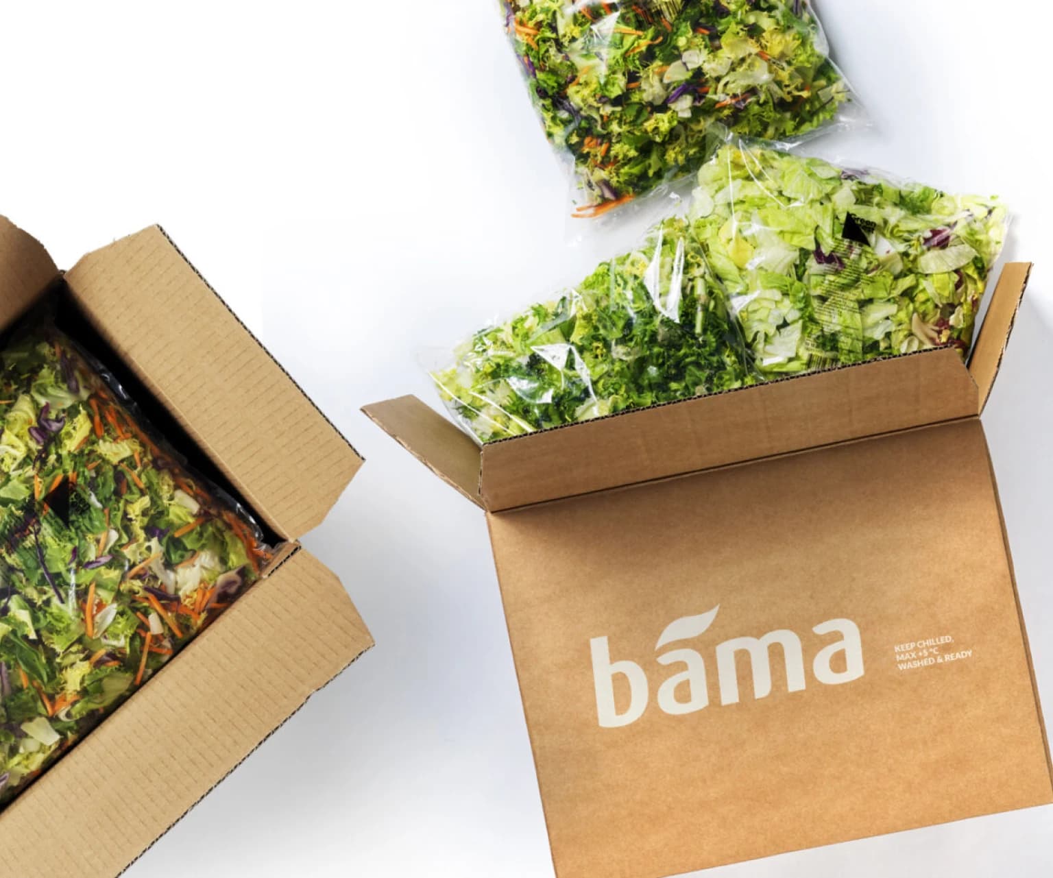 BAMA cardboard boxes filled with packaged fresh salad mixes and leafy greens.