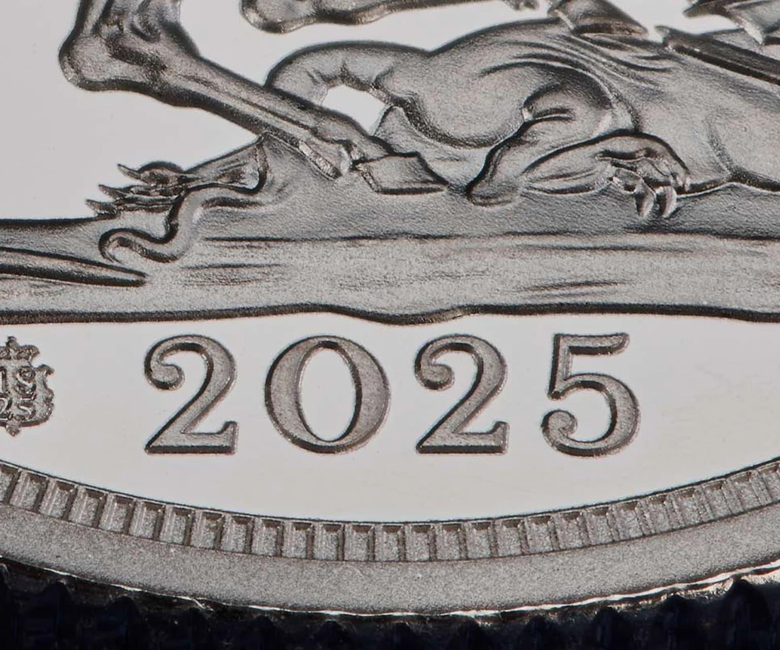Close-up of a coin showing the year 2025 engraved with detailed embossed design.