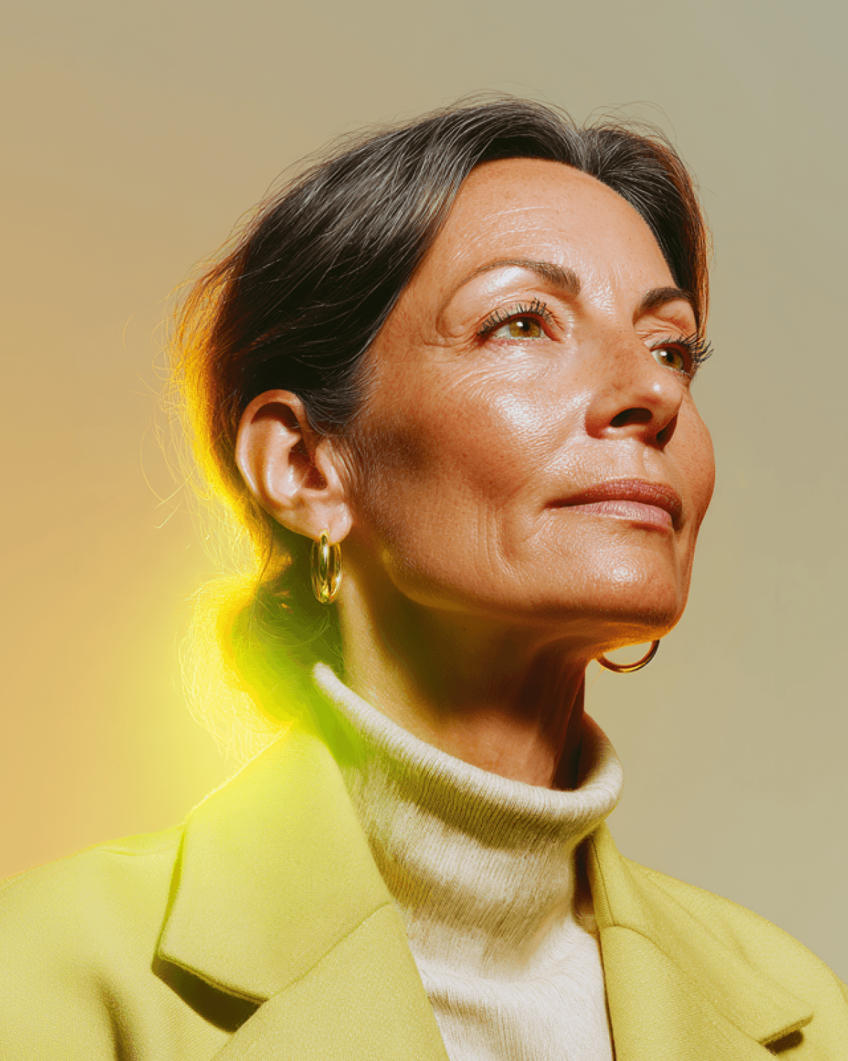 Confident older woman in a yellow blazer and turtleneck, looking upward with warm golden light behind her.