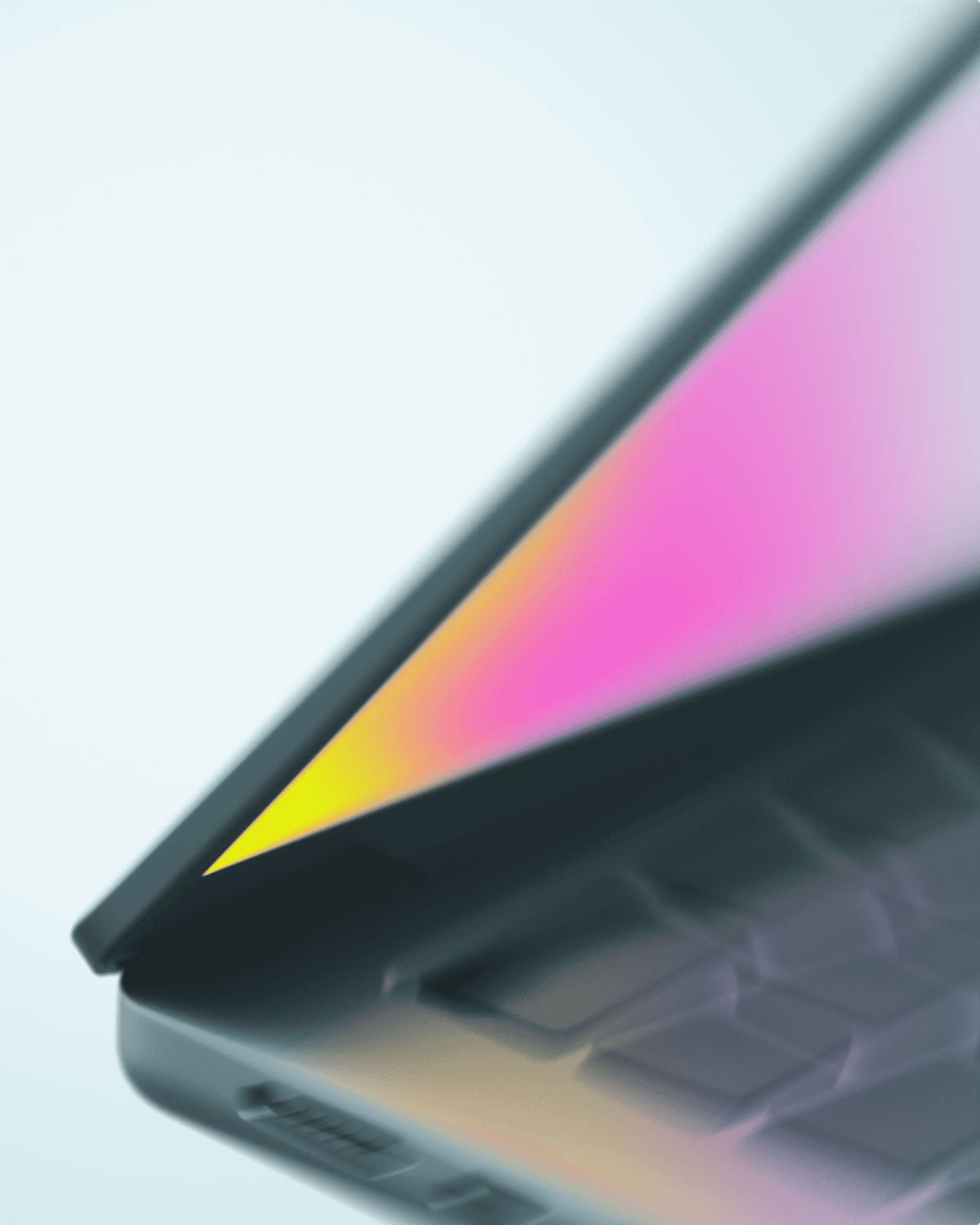Close-up of a modern laptop partially closed, with screen glowing in pink and yellow gradient.